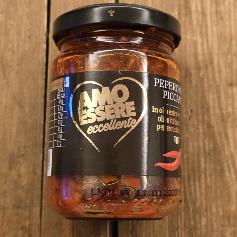 Barattolo di peperoncini piccanti "Amo Essere Eccellente" (150g) su sfondo legno, etichetta oro/nero con cuore stilizzato e peperoncino rosso