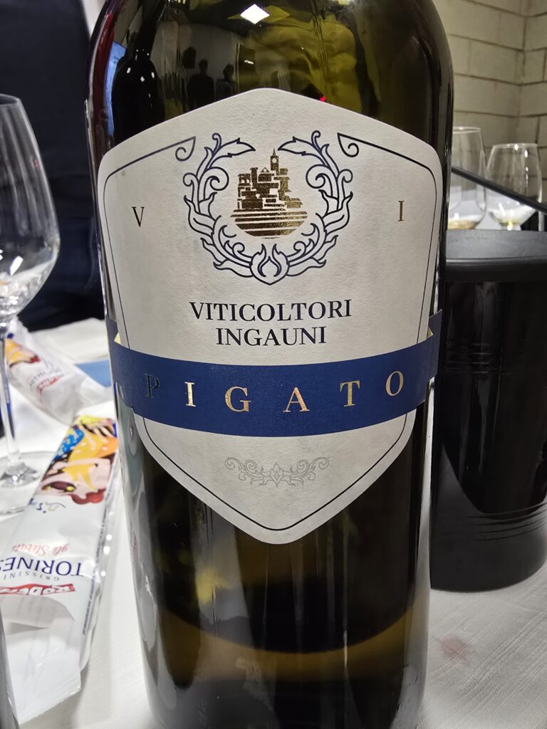 Bottiglia di Viticoltori Ingauni Pigato Riviera Ligure di Ponente con etichetta araldica blu su tavolo da degustazione