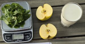 Latte, mela con la buccia e menta fresca su bilancia da cucina, i tre rimedi contro l'alito d'aglio testati nell'articolo