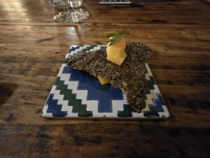 Antipasto di Trattoria La Madia servito su piastrella decorata, cialda di semi e frutto