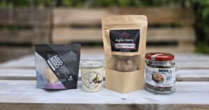 Quattro confezioni di aglio nero allineate in ordine di prezzo crescente: Nero Fermento, Aglio Nero Gourmet, Nero di Sulmona, vasetto artigianale di Vessalico