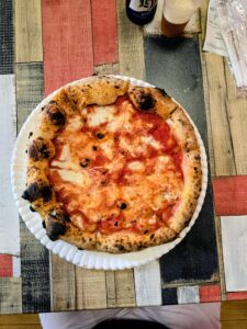 Pizza Margherita intera vista dall'alto, con birra Leffe, alla pizzeria Napule di Lecco