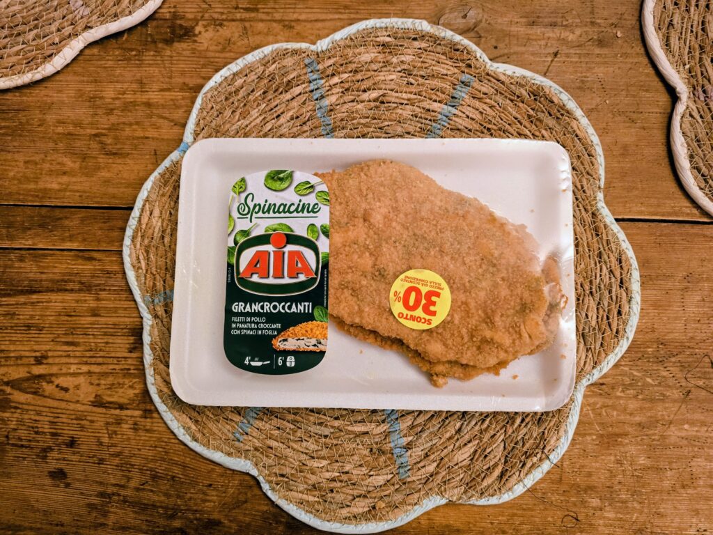 Confezione di Spinacine Grancroccanti AIA con filetti di pollo panati su sottopiatto intrecciato